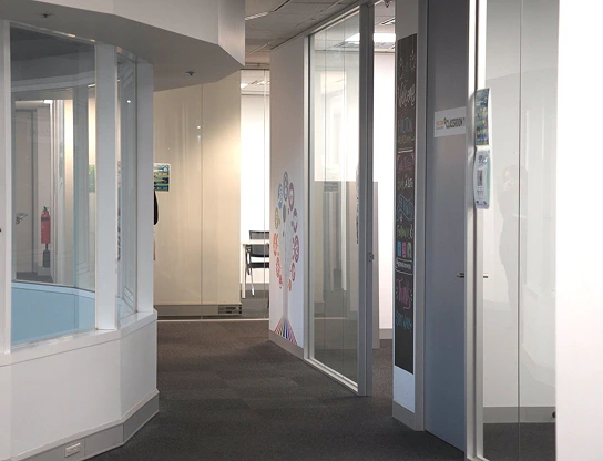 A well lit hallway showing multiple classrooms and study places on campus at Laurus Higher Education.